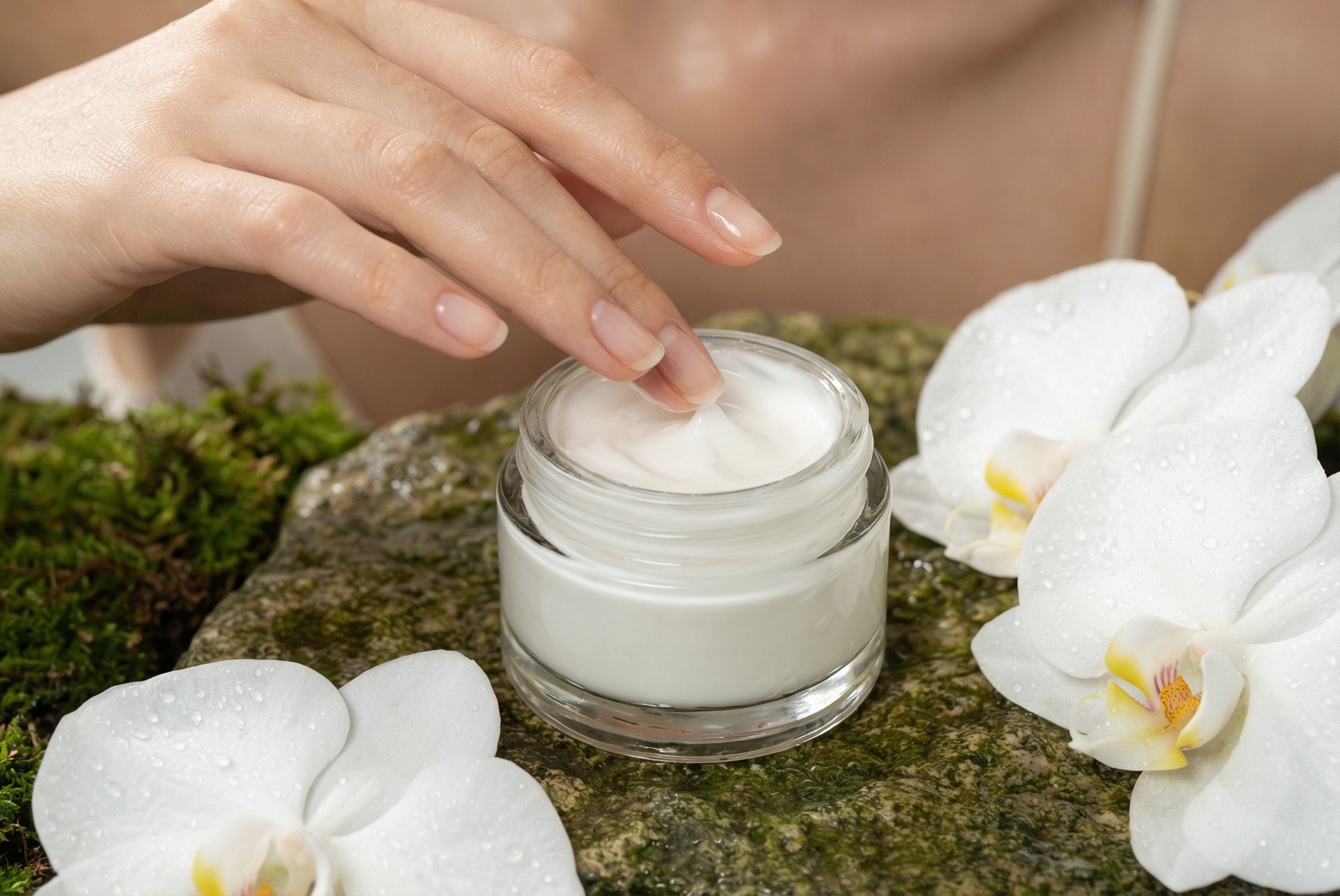 High-end beauty editorial photography. A graceful fashion model with flawless, dewy, glowing skin and gently pulled-back wet-look hair is sitting amidst the mossy, natural stone surface. Her elegant hand, with natural manicured nails, is gently dipping into the open clear glass jar of luxurious, rich white moisturizing cream. Dewy white orchid petals, green leaves, and splashing clear water droplets surround her and the product. Soft, natural diffused daylight illuminating her face and the creamy texture. Serene expression, eyes slightly closed in enjoyment. Organic, pure hydration concept. 8k details, shot on Hasselblad.